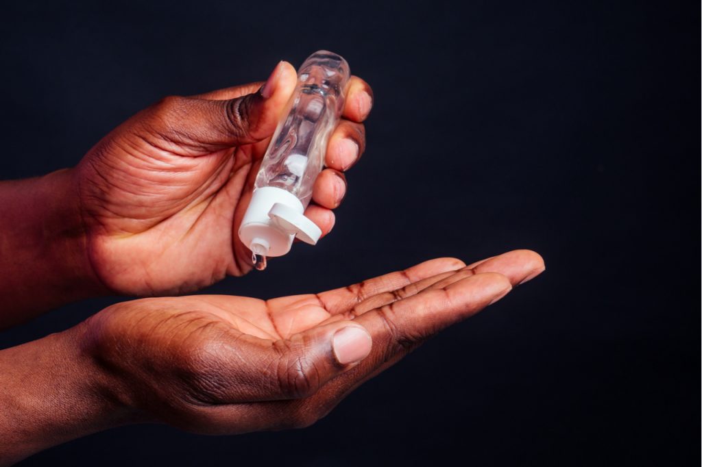 An image of a man using a hand sanitizer.