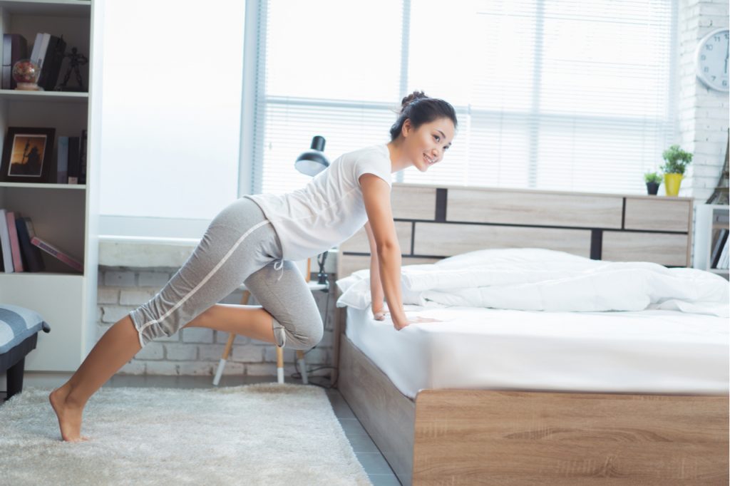 Woman exercising in bed after waking up.
