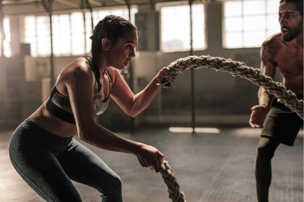 Fit woman doing rope training.