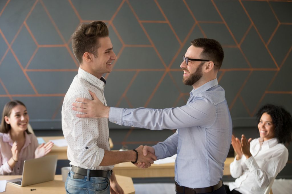 Team leader handshaking employee congratulating with professional achievement