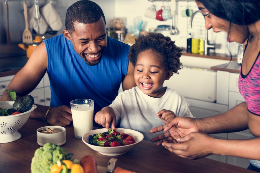 A family of 3 having fun while eating.