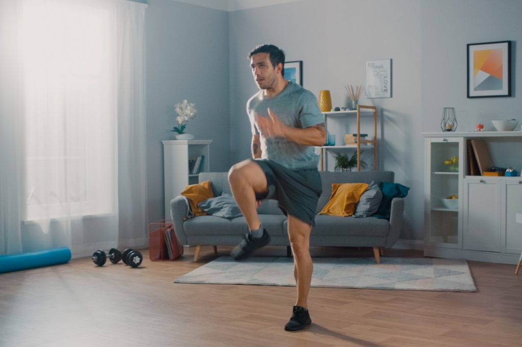 A man jogging in place in his living room.