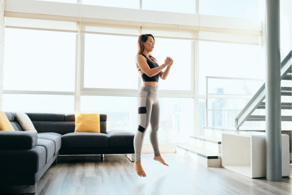 Woman training legs muscles with squats and jumps.