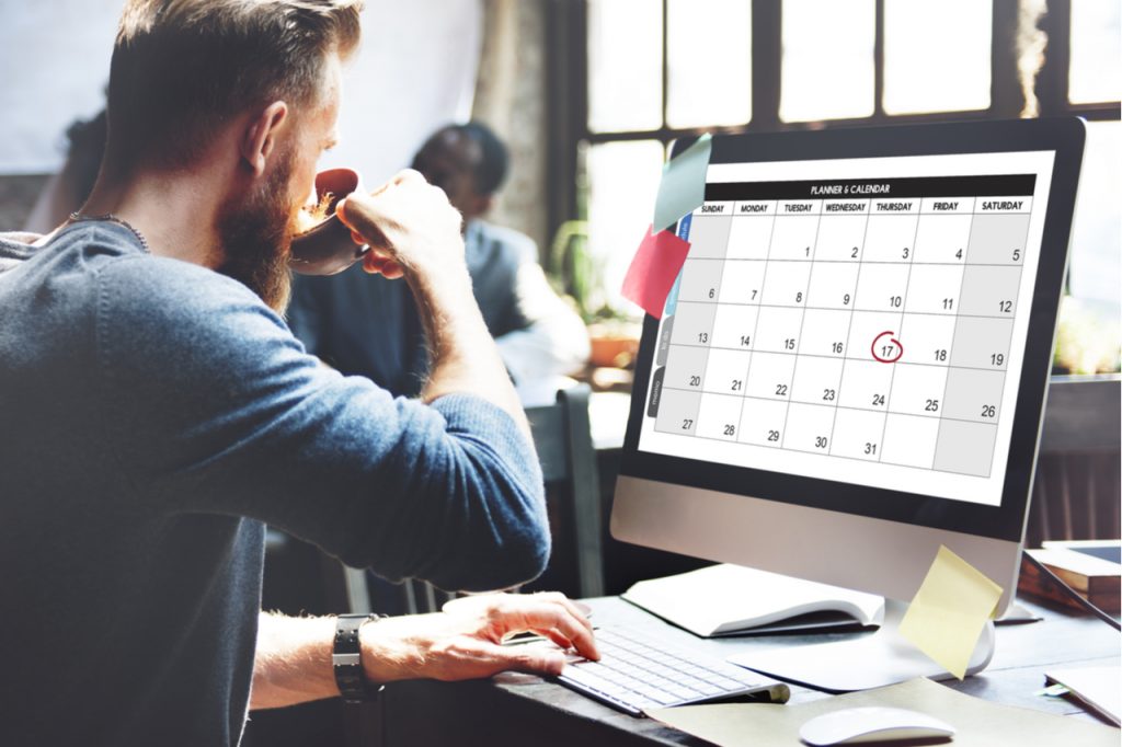 Man looking at the calendar on his computer.