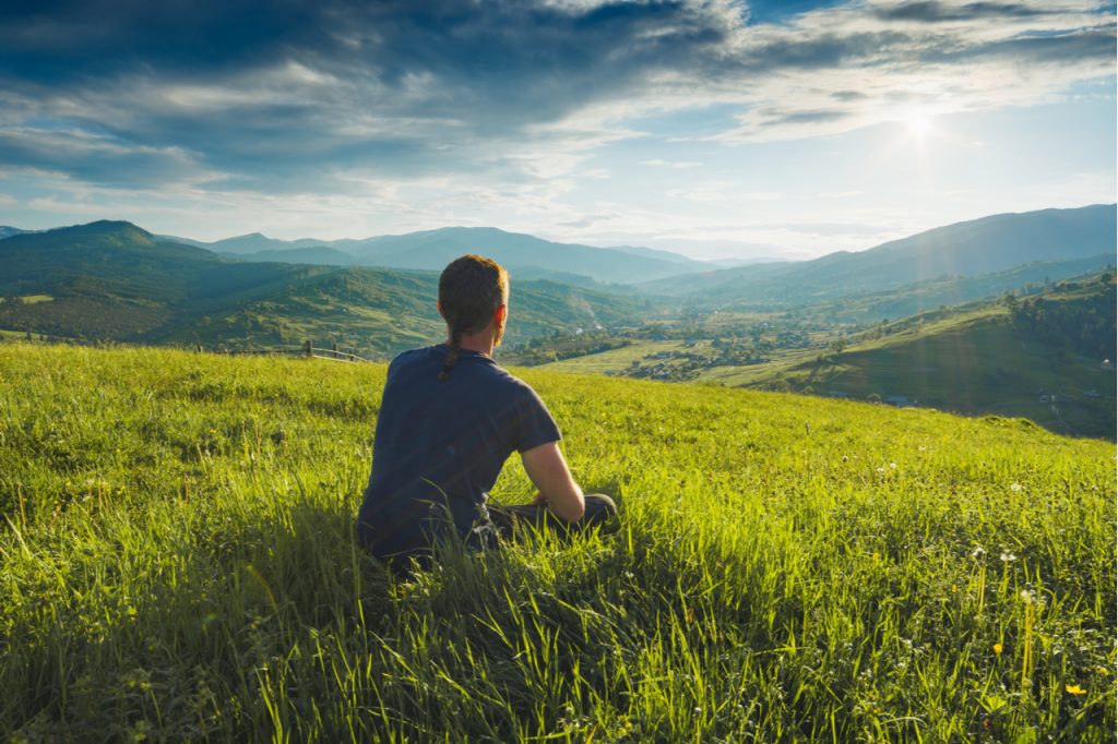 A man sitting while appreciating the natures view.
