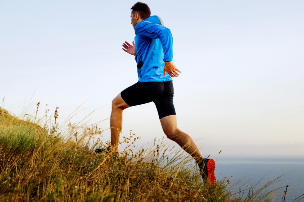 Man athlete running up the mountain.