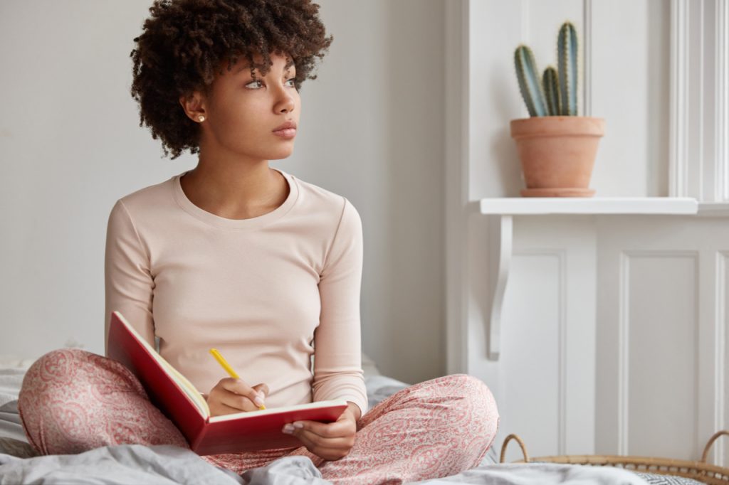 A woman journaling for mental health a way on how to stay focused.
