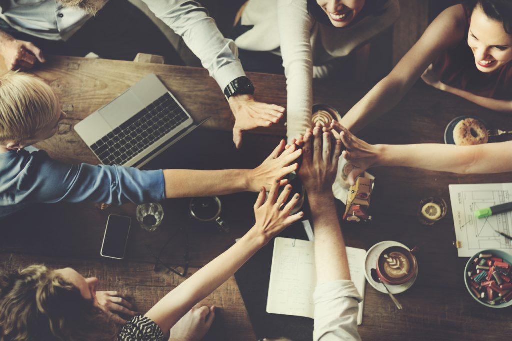 A group of people joining hands showing team spirit.
