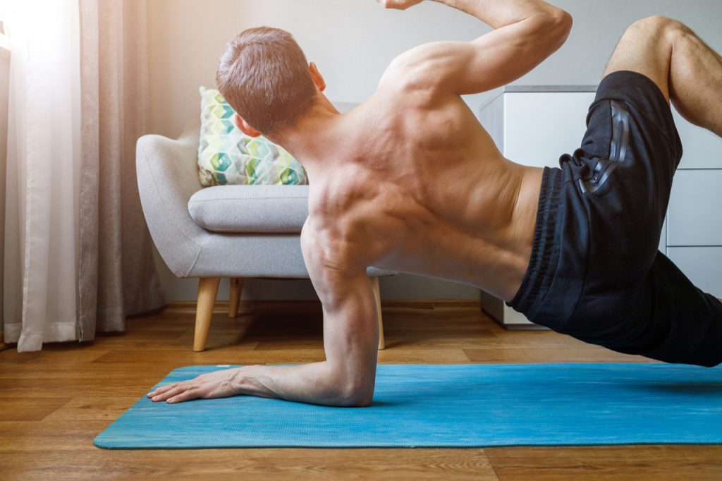 A man doing walking plank in his living room