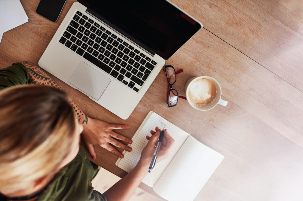 Woman writing down her goals. One way on how to stay motivated.