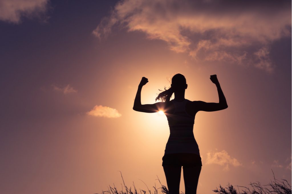 A silhouette of a woman flexing her arms. Visualize your Goals to achieve them.
