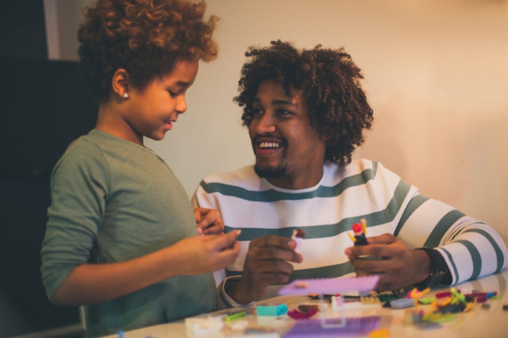 African American father and daughter playing with cubes.