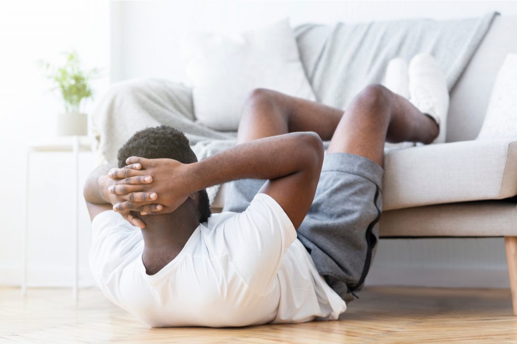 Man doing abs training and crunches in living room.