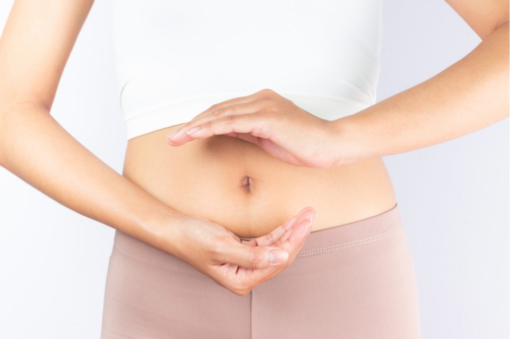 A woman forming a circle with her hands in front of her stomach which supposedly means that she has good digestive system function.