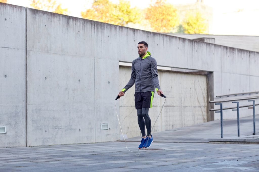 Man exercising with jump-rope outdoors