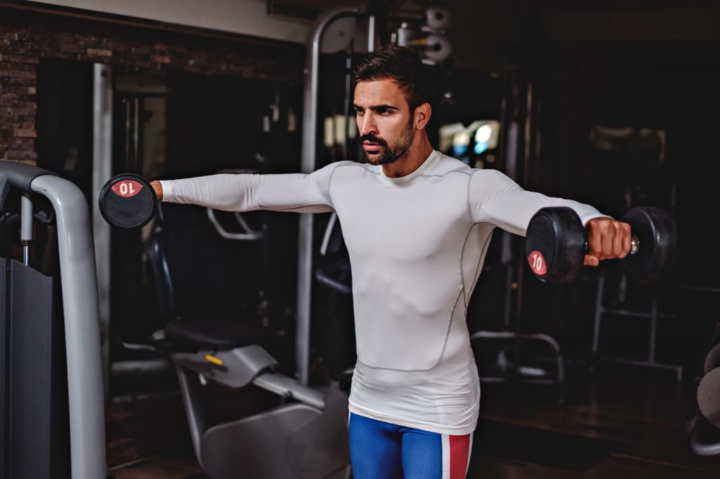 Man doing lateral arm raise with a dumbbell.