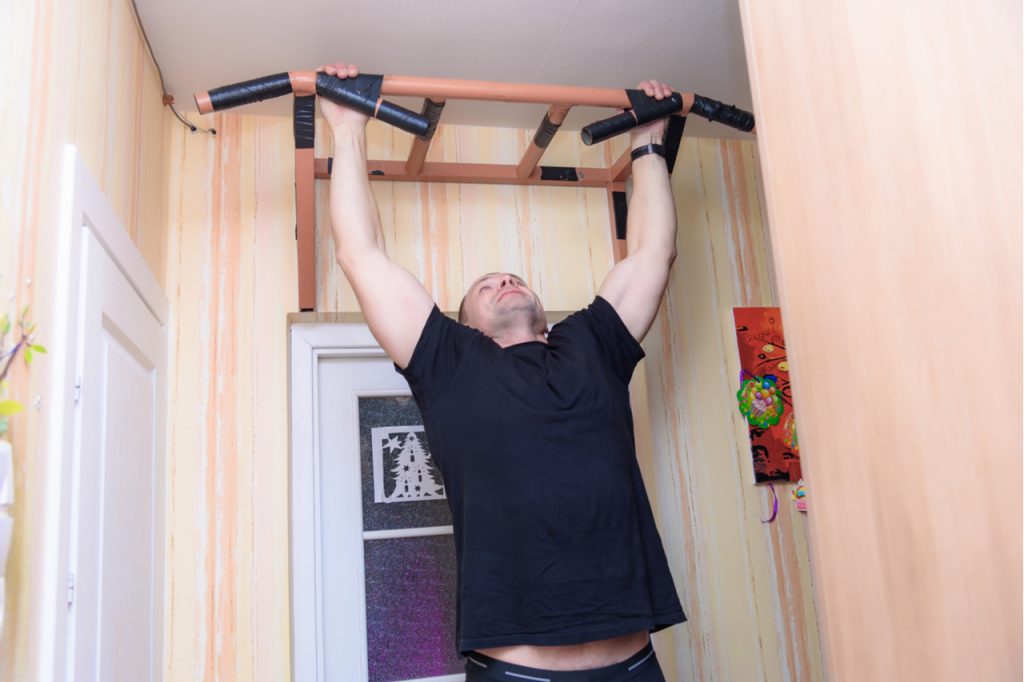 A man doing pull ups at home.