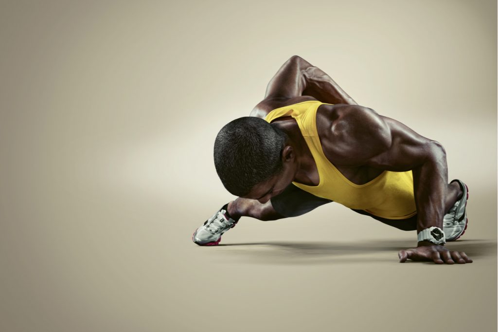 Young athletic man doing push-ups.