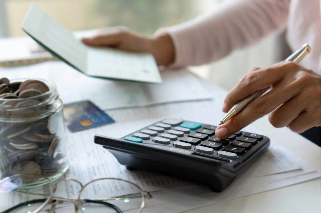 Woman checking bills, taxes, bank account balance and calculating credit card expenses.