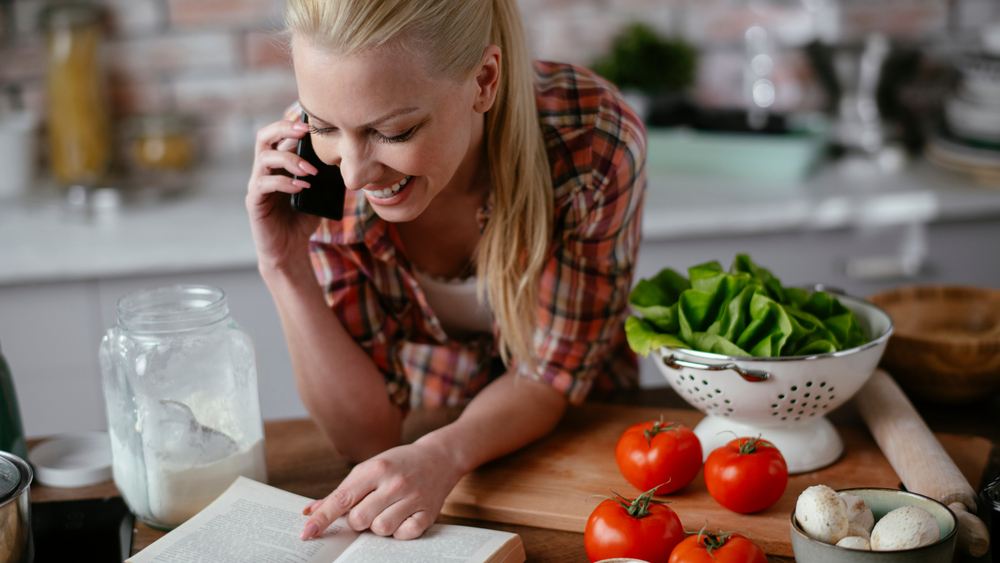 Young woman cooking in kitchen. Beautiful woman making delicious food.