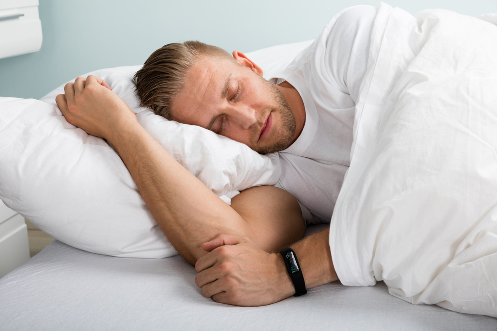 Young Man Sleeping On Bed With Eyes Closed