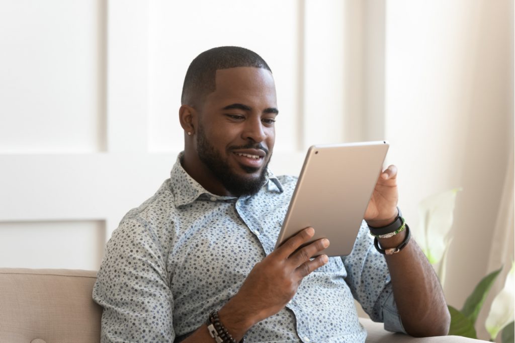Man using digital tablet at home checking news or social media getting informed.