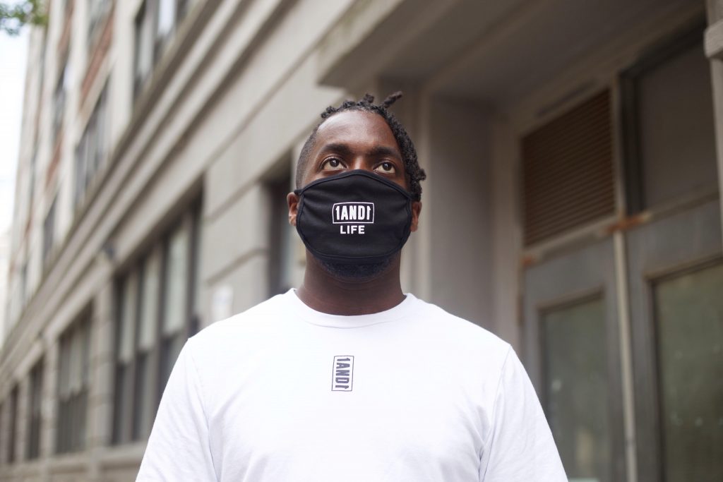 model wearing a reusable face mask with 1AND1 Life logo