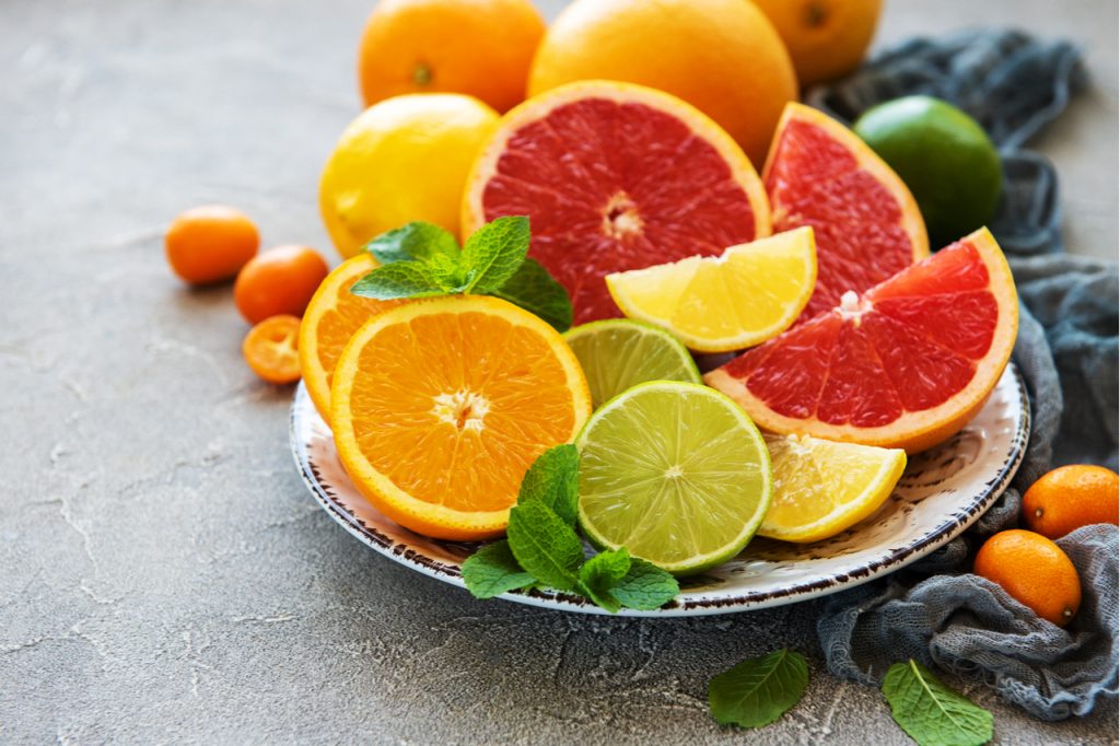 Sliced orange, lime, and lemon on a platter. Eat fruits rich in vitamin C that is how to boost the immune system.