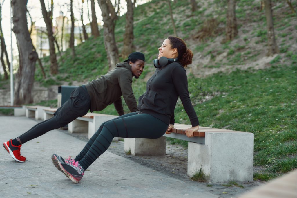 A couple working out in a park.