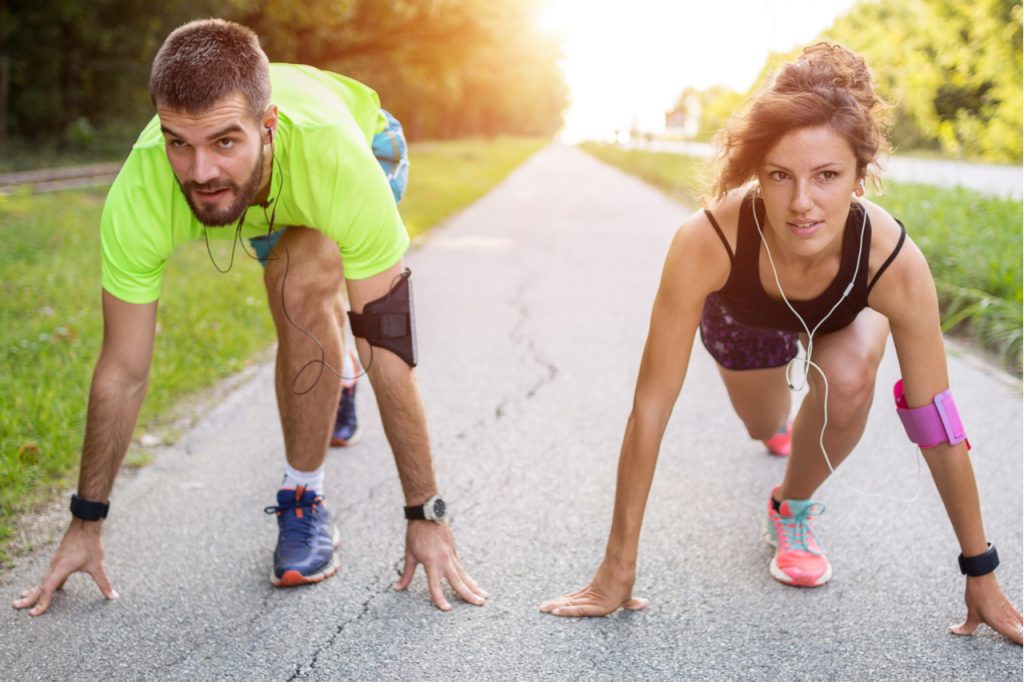 A couple getting ready to run both wearing a fitbit so that they can export fitbit data for fitness tracking.