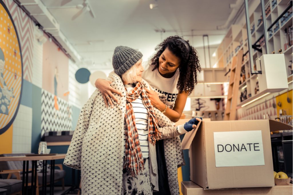 A woman donating clothing and other items to the less fortunate.