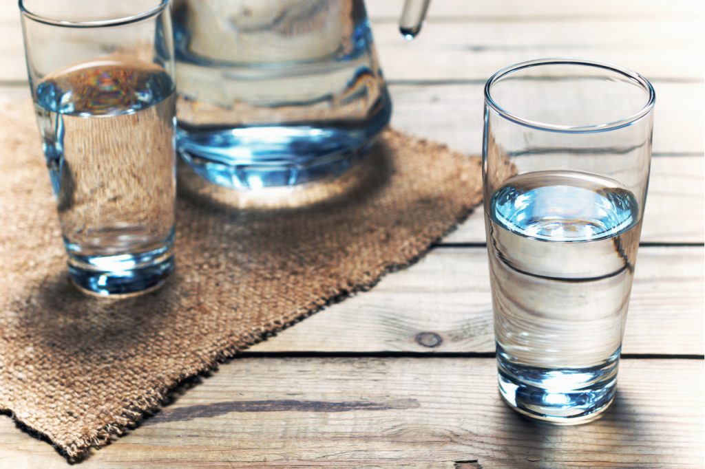 Glasses of water on a wooden table. Selective focus.