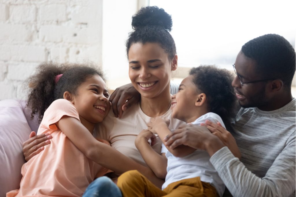 Happy family with two kids enjoy time together in the living room.