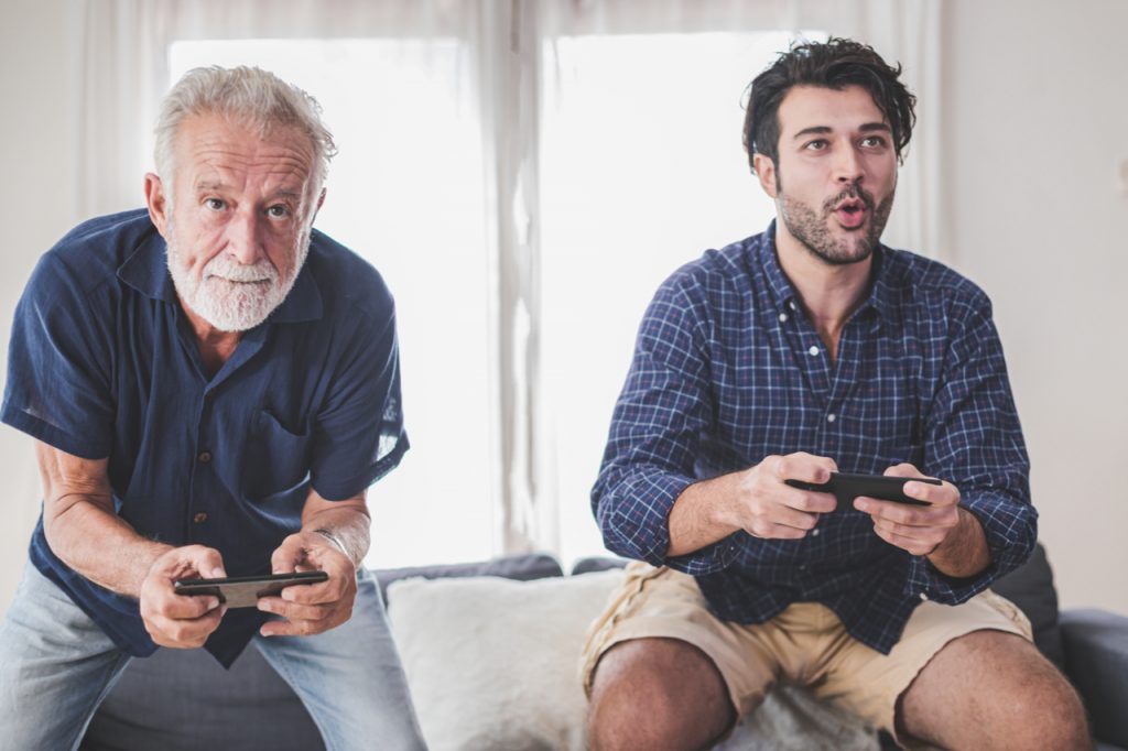 Father and son playing a video game together. One of the fun things to do at home.