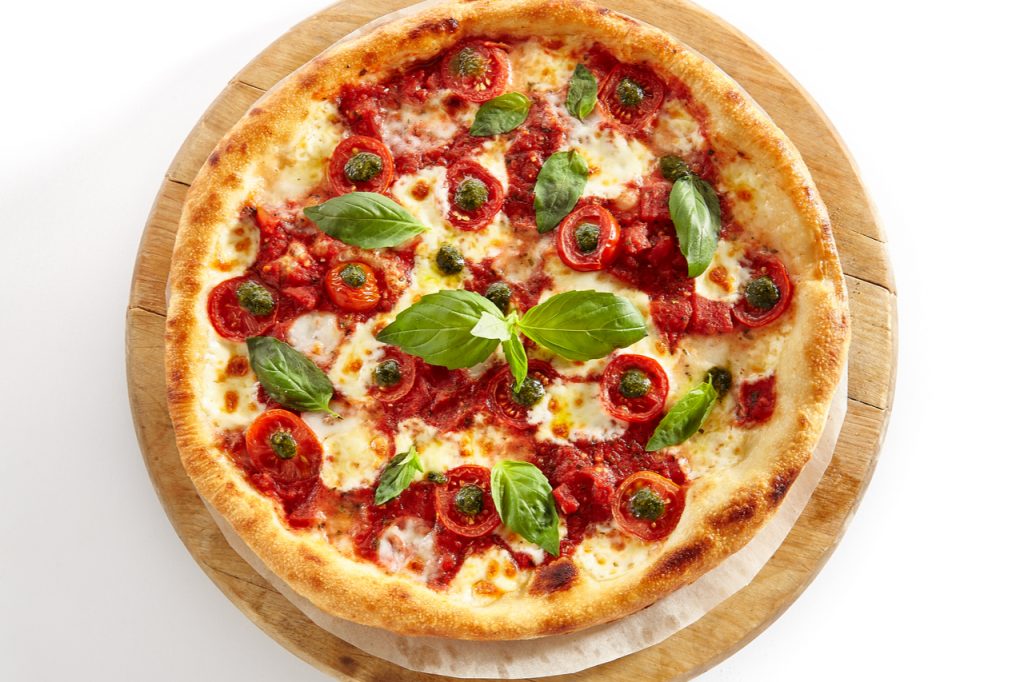 Healthy Halloween Pizza, with cherry tomatoes and fresh basil as toppings.