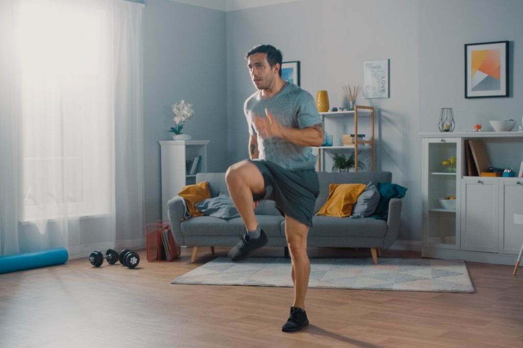 Man is energetically jogging in place at home.