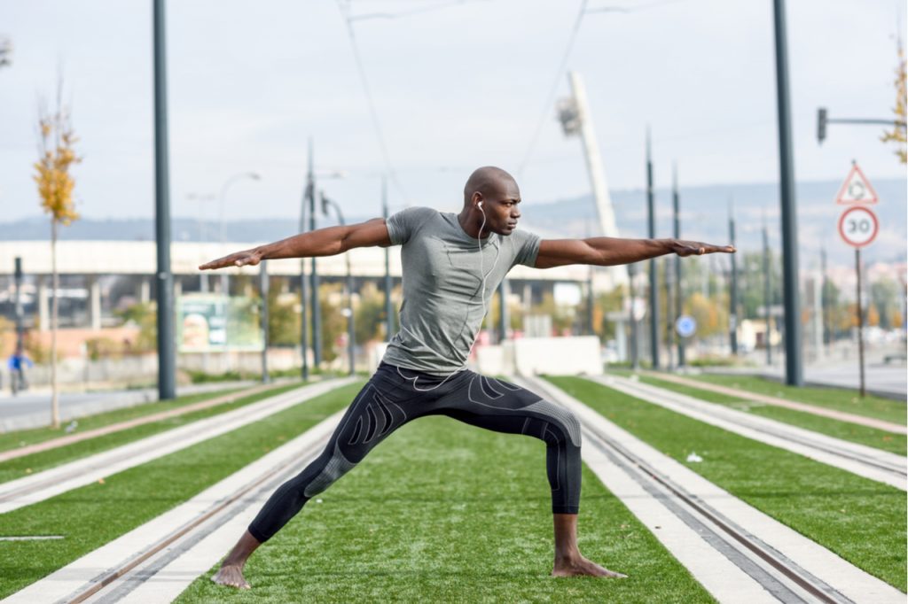 Man practicing yoga in urban background getting in control.