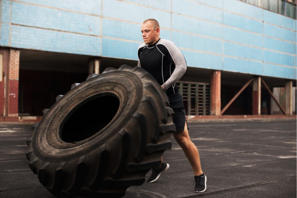A man lifting a big tire as his Hero WODs