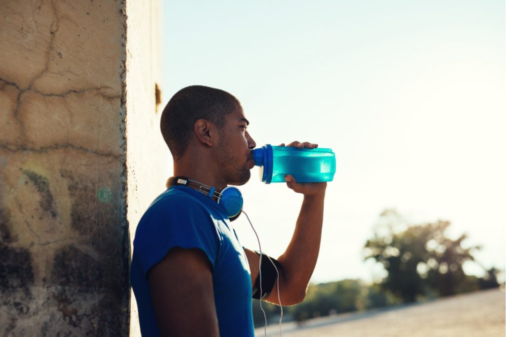 An African American man drinking water.