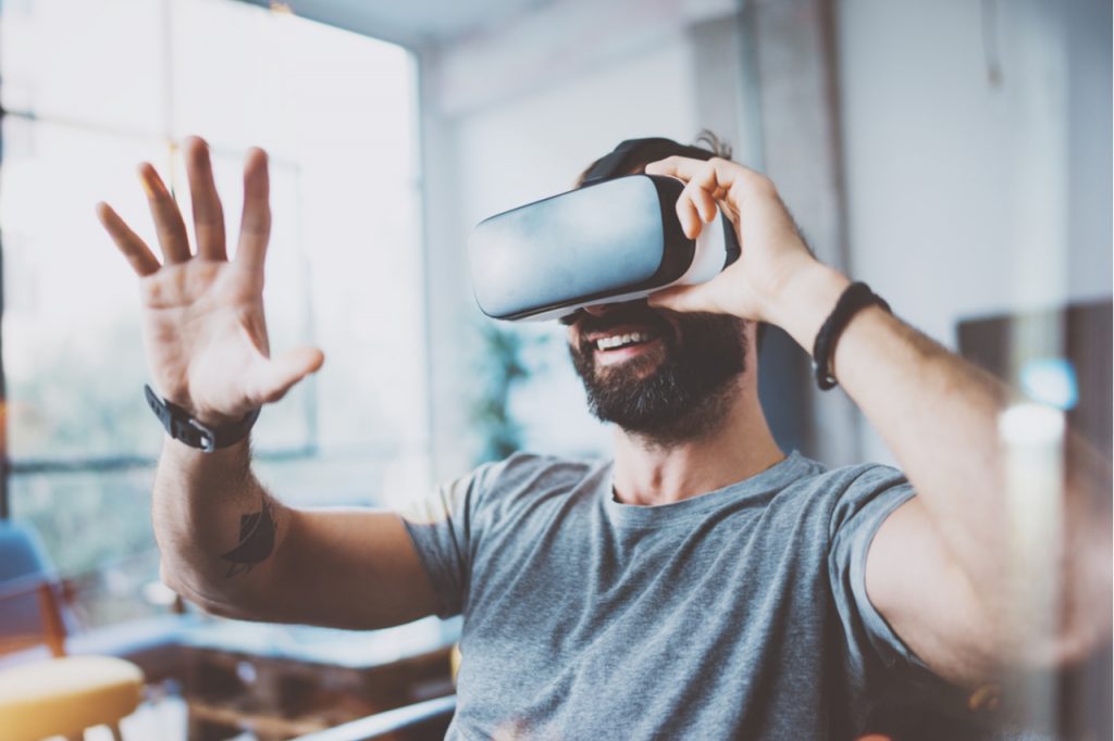 Man wearing a virtual reality glasses and he's having fun.