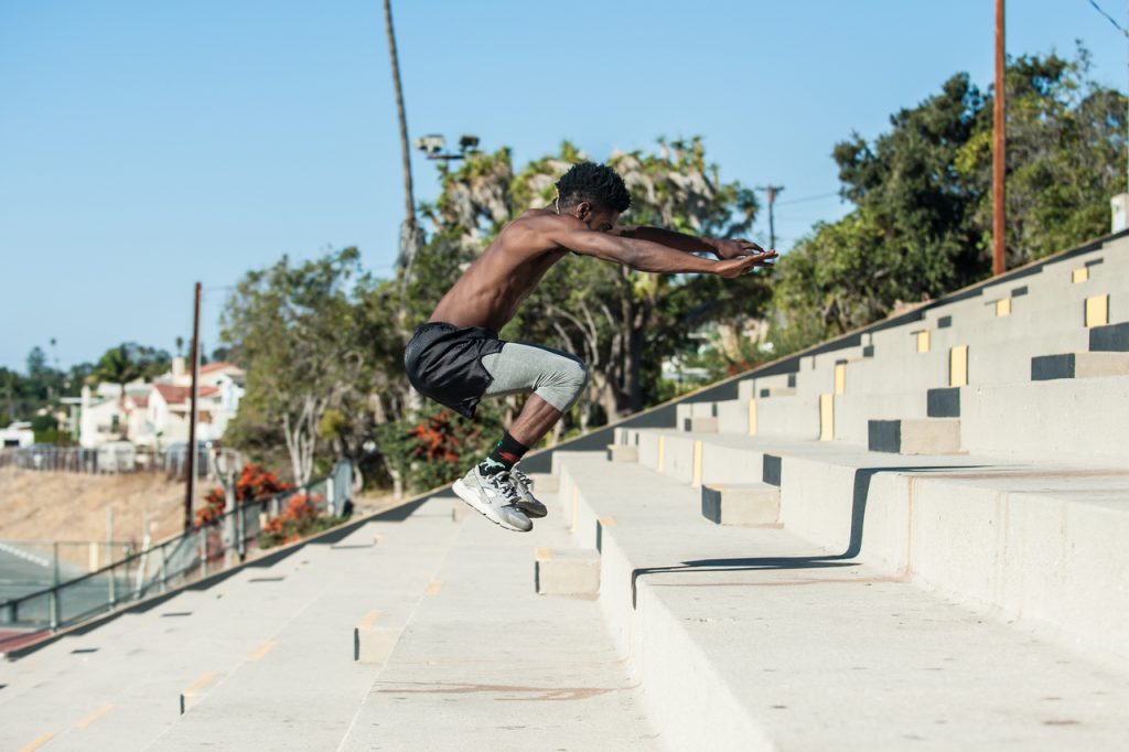 Athlete increasing power with plyometric workout at stadium steps.
