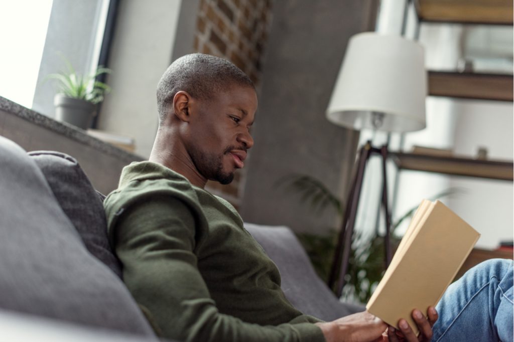 A man reading book at home.