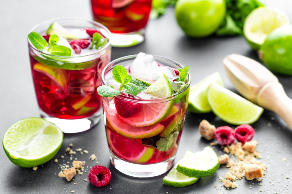 Raspberry cocktail with lime, mint and ice, cold, iced refreshing drink or beverage.