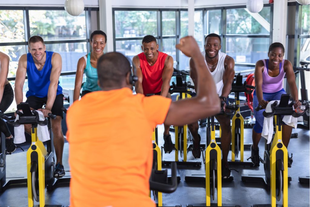 A multi-racial spinning class. Join a group personal training class to keep you motivated.