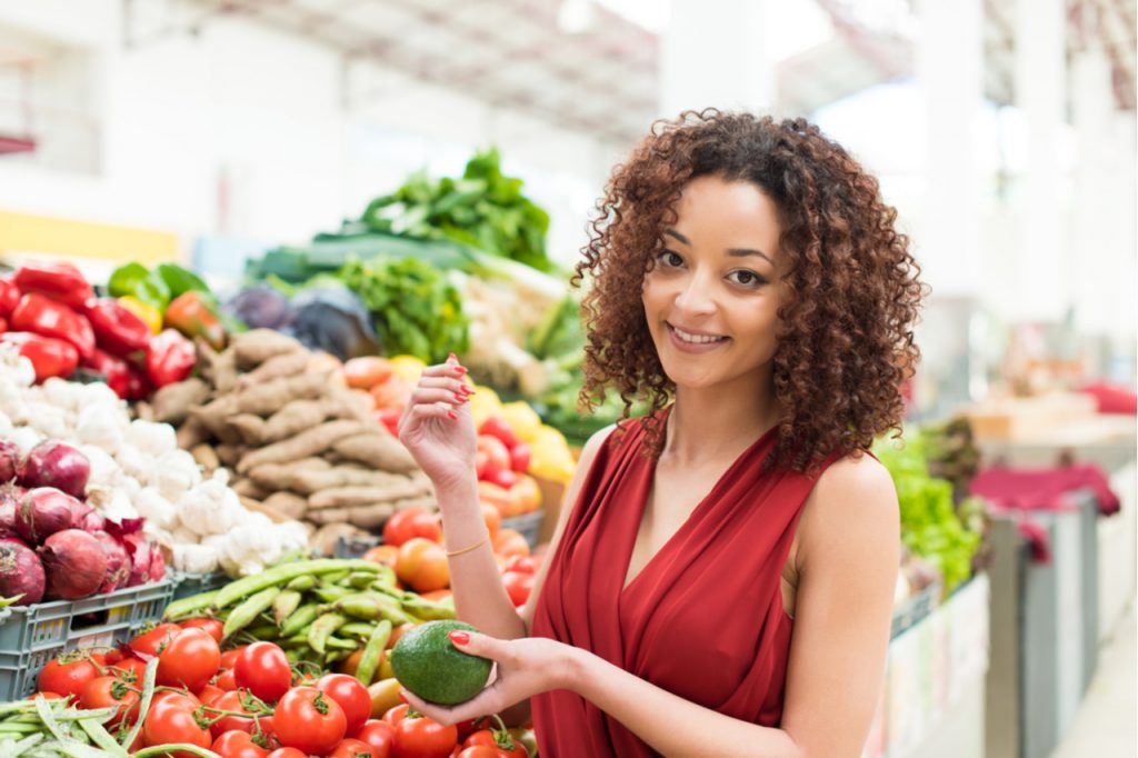 An Afro woman buying vegetables at the local market.