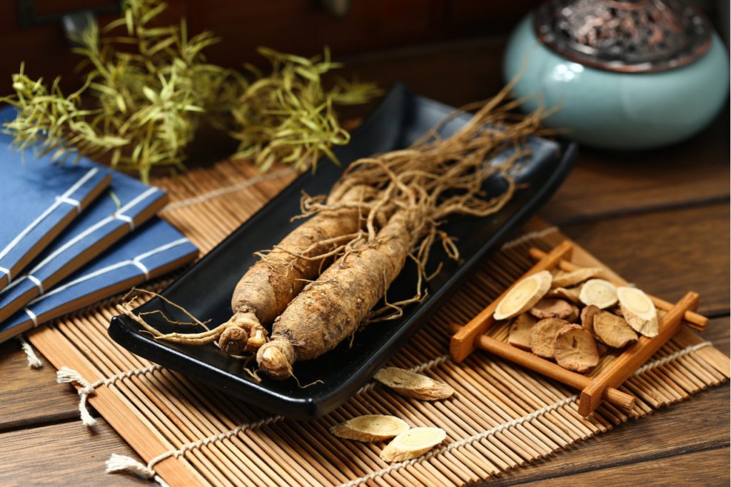 Ginseng in black plate on wooden table.