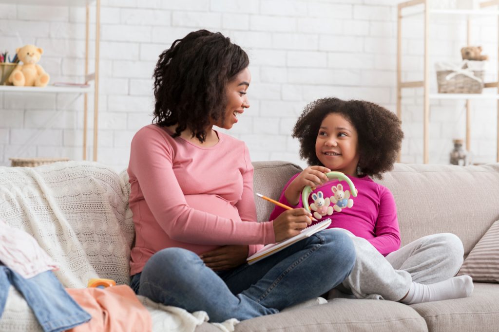 Mother and daughter writing a routine while sitting on the couch.