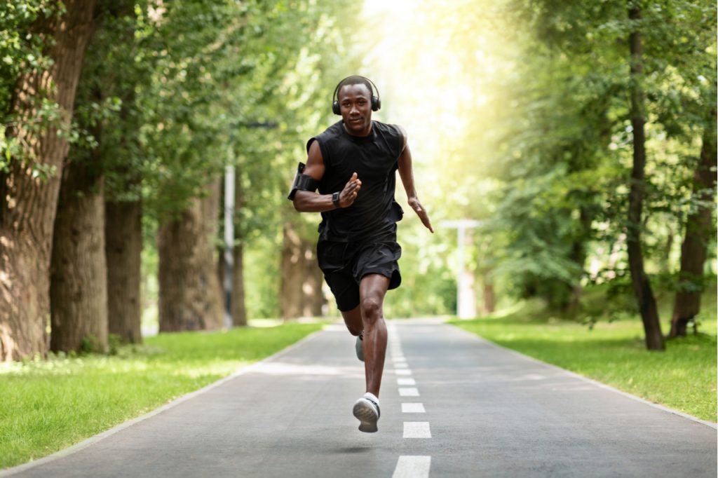 An African American doing his daily run while wearing a headphone.