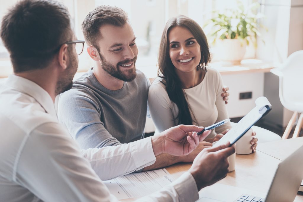 A couple discussing refinancing their loan to a bank associate.