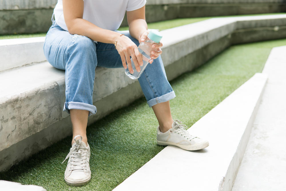 Woman using personal reusable water bottle.